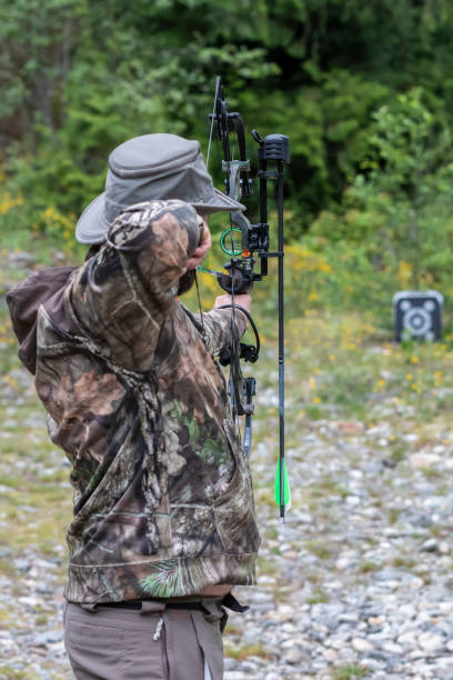 istock A Man Wearing Camouflage Shooting a Compound Bow at a Target 993466884