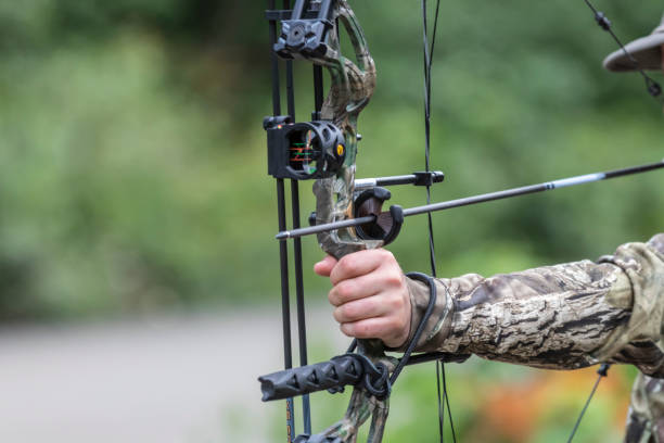 jemand hält eine zusammengesetzte jagd pfeil und bogen - archery bow arrow women stock-fotos und bilder