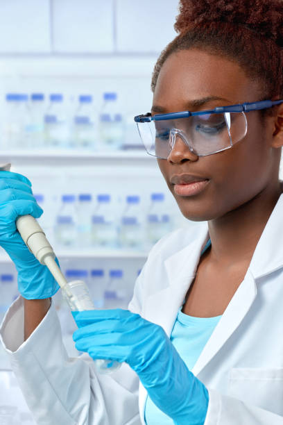 istock African-american scientist or graduate student in lab coat loading samples with pilette 993467518