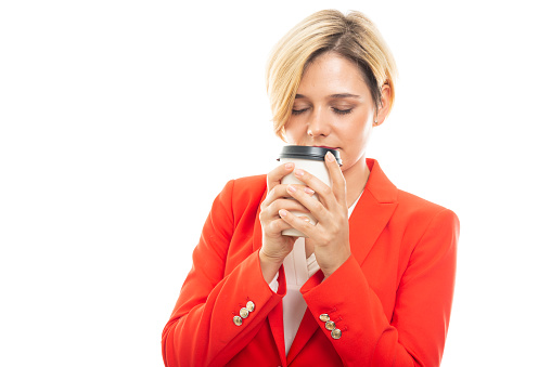 Young pretty business woman smelling takeaway coffee cup on white background with copyspace advertising area