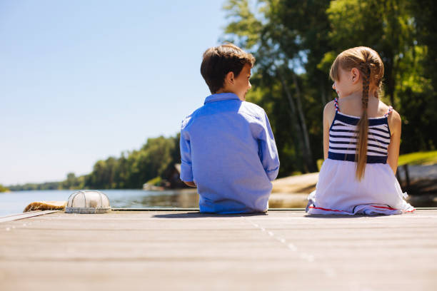istock Sweet little siblings sitting on pier 993477976
