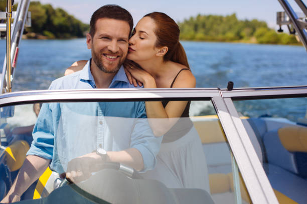 istock Affectionate young woman kissing husband sailing a boat 993478458