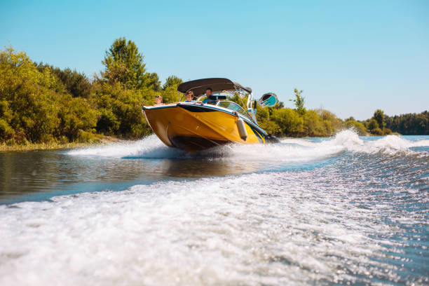 piacevole giovane famiglia che si gode un giro in motoscafo lungo il fiume - motorboat foto e immagini stock