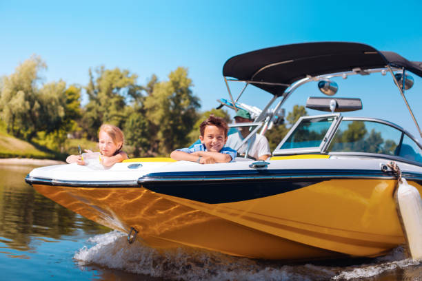 hermanos poco alegres disfrutando de la vista de proa de barco - motorboat fotografías e imágenes de stock