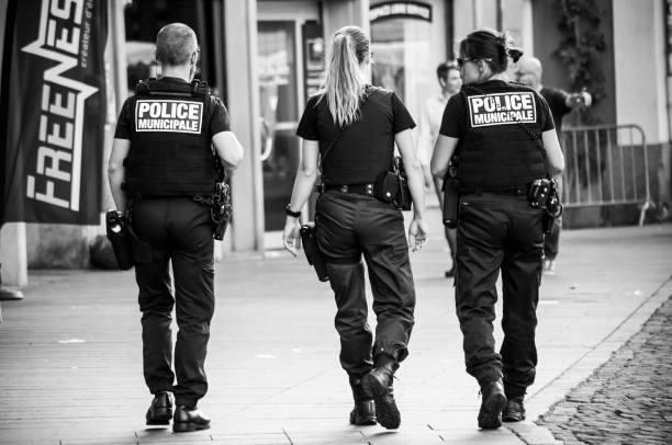municipal police women and police man  walking in main place on back view Mulhouse - France - 4 July 2018 -  municipal police women and police man  walking in main place on back view mulhouse photos stock pictures, royalty-free photos & images