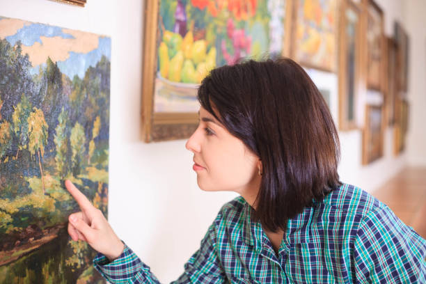 istock Young woman looking at painting. 993565014