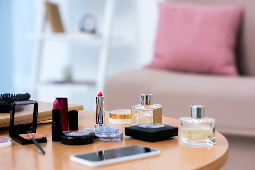 close-up view of smartphone and various cosmetics on table