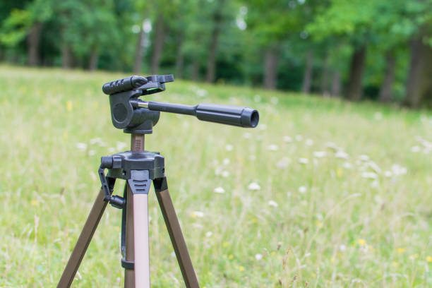 istock A tripod for the camera standing on a green glade. 993581994