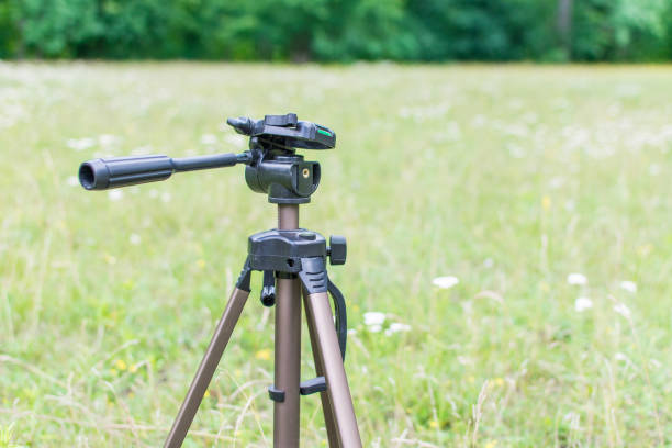 istock A tripod for the camera standing on a green glade. 993582262