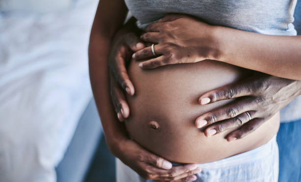 We're going through this pregnancy together Cropped shot of an unrecognizable man and his wife touching her pregnant belly huge black woman pictures stock pictures, royalty-free photos & images