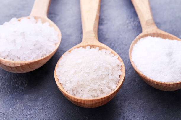 istock White sea salt in spoons on grey wooden table 993610860
