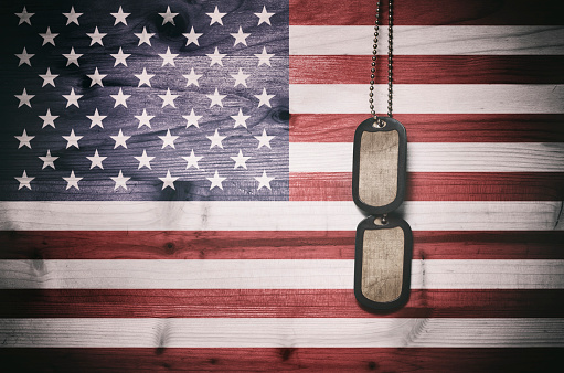 Military dog tags on American flag background