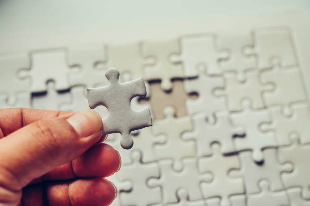 istock Handle a piece of white puzzles that are about to drop to get a complete worksheet - An attempt to succeed. 993616600
