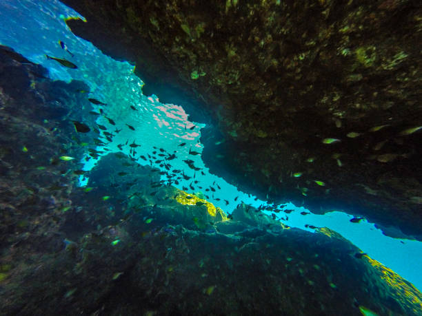 The underwater scuba diver point of view from within a submerged cave system in Thailand.  Cave diving is notoriously difficult and dangerous, requiring specialist training.  Image taken at a famous dive site called ‘The Chimneyl’ in Ko Haa, Andaman Sea, Krabi, Thailand.