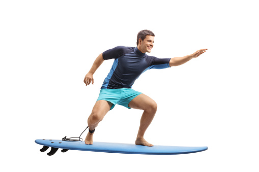 Full length profile shot of a surfer surfing on a surfboard isolated on white background