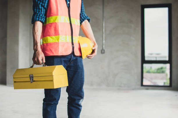 worker holding construction box and helmet preparing to work in working site stock photo