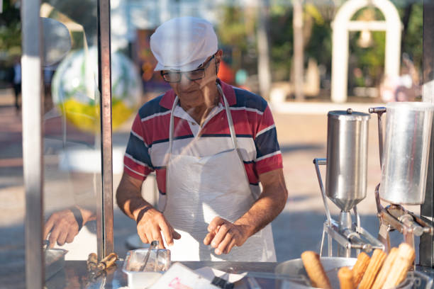 istock Mature Man selling churros at street 993631708