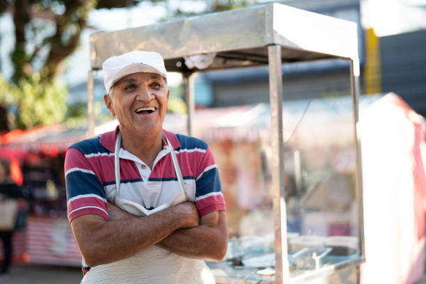 oudere man verkopen churros op straat portret - straatverkoper stockfoto's en -beelden