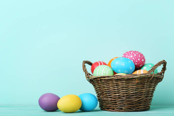 istock Colorful easter eggs in basket on wooden table 993635568
