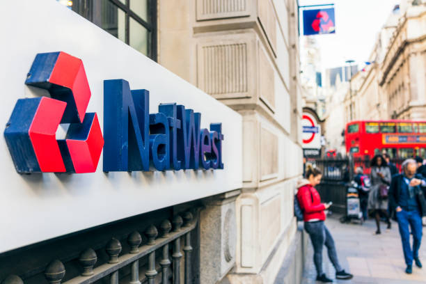 London, UK - People on the street outside a branch of NatWest bank in central London.