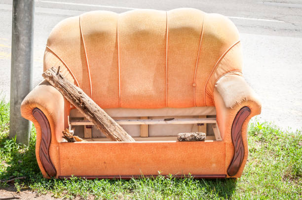 Old orange sofa thrown in the garbage from home on the street