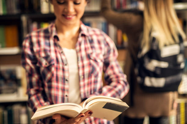 istock Young female student is pleased she found the book she needed in a library. 993658178
