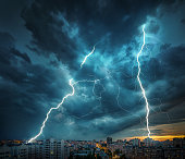 Lightning thunderstorm flash over the night city.