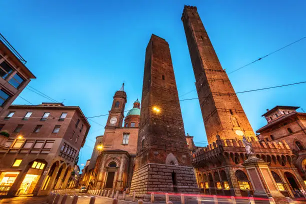 Two famous falling Bologna towers Asinelli and Garisenda. Evening view, long exposure. Bologna, Emilia-Romagna, Italy.