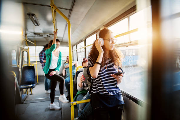 istock Young adorable woman is adjusting her headset and looking through the bus window while waiting to arrive at her destination. 993660216