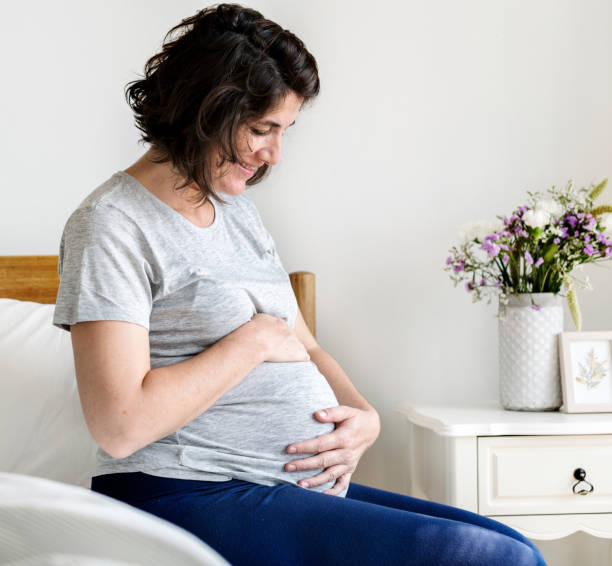 istock Pregnant woman sitting on the bed 993662594