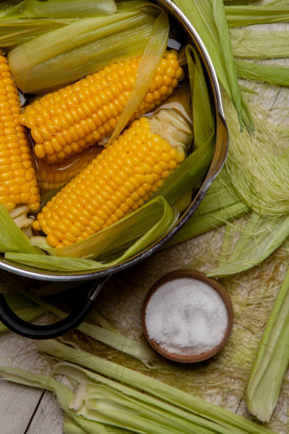 istock Sweet corn boil with salt. cooked sweet corn in pot on wooden table. 993667250