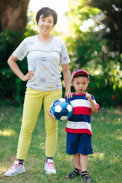 istock Mother and son with soccer ball posing for camera 993676908
