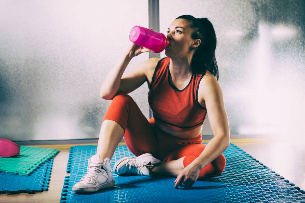 istock Exhausted woman drinking water after sports training 993687252