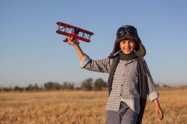 istock Boy playing with toy airplane in the field 993701314
