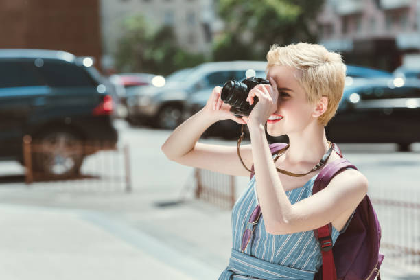 istock traveler with backpack taking photo on camera in city 993702780