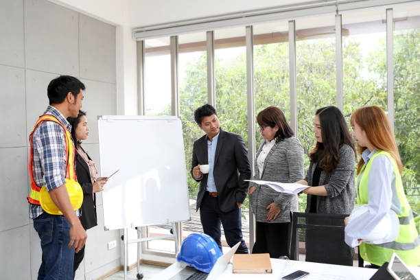 istock Engineers are meeting on the whiteboard. Blueprint Interior Design structure and development. contractor presentation for team and client in the office. asian people. Business brainstorming and discussion. 993706032