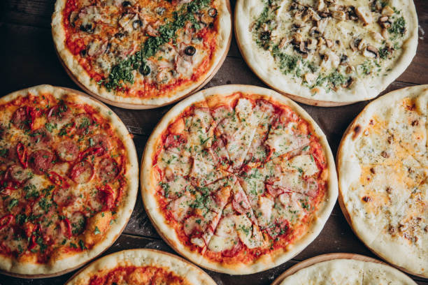 istock italian pizzas in a black concrete background. Copyspace Top view Banner 993714106