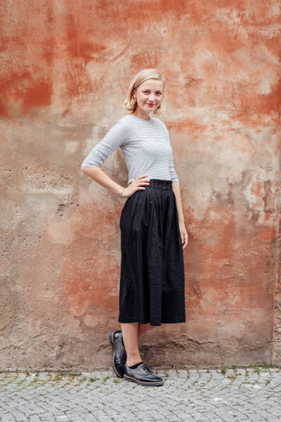 istock Confident woman standing against red wall 993715146