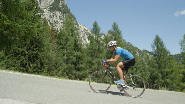 istock Determined road cyclist pedals himself uphill during exhausting bicycle race. 993718524