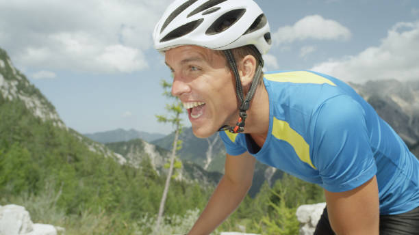 istock CLOSE UP: Exhausted fit road cyclist bikes up a beautiful sunny mountain road. 993718746