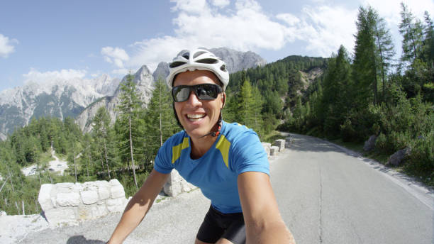 istock SELFIE: Caucasian man smiles into the camera as he rides up a steep mountain. 993718752