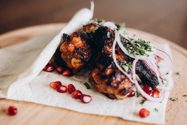 istock Grilled meat with fresh herbs, vegetables  on rustic wooden board 993719026