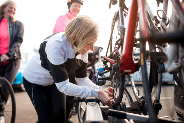 Finishing a Bike Ride Mature woman putting her bikes on a bike rack on her car. bicycle rack photos stock pictures, royalty-free photos & images