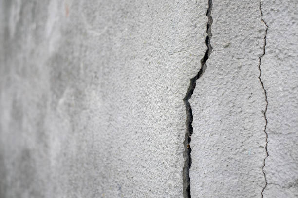 istock Old foundation and plaster wall with cracks. Building requiring repair closeup 993741288