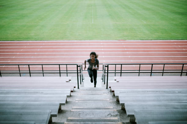 woman athlete runs stairs for track and field - track and field stadium imagens e fotografias de stock