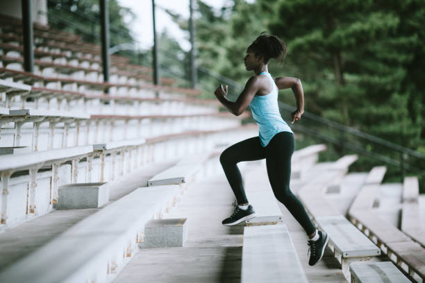 woman athlete runs stairs for track and field - track and field stadium imagens e fotografias de stock