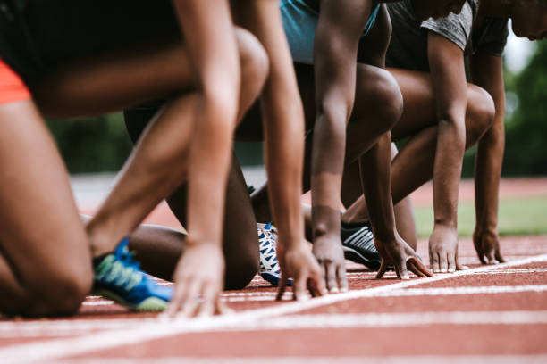 Asian chinese athletes sprint running at track and run towards finishing line in the morning at track and field stadium