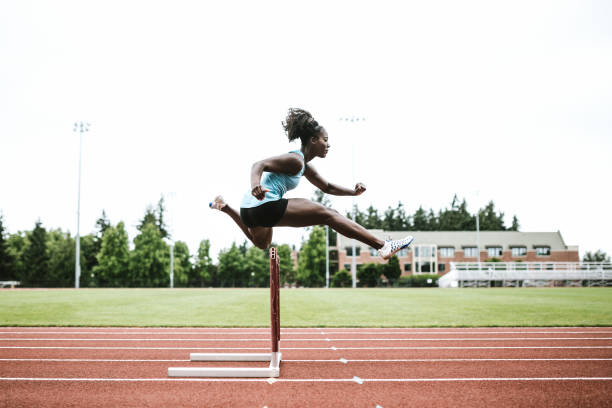 mulher atleta corre com barreiras para pista e campo - hurdling usa hurdle track event - fotografias e filmes do acervo