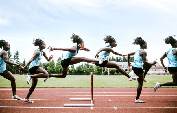 athlète féminine s’exécute des haies pour l’athlétisme - hurdle competition hurdling vitality photos et images de collection