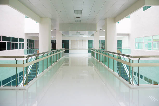 Empty modern hospital or school corridor, clinic hallway interior in yellow-white collor and led lighting